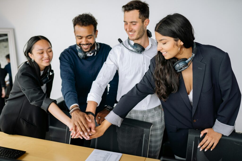 Four People Stacking Hands | Administrative Support | Boomerang Partners Global